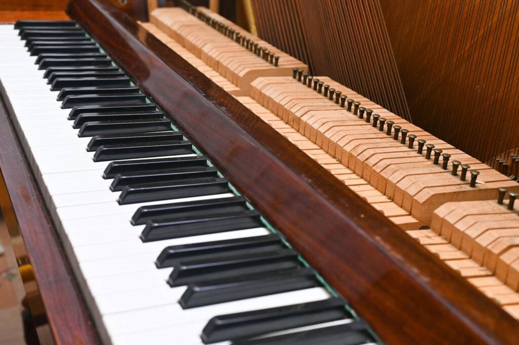 the keyboard on the disassembled piano. The piano is under repair